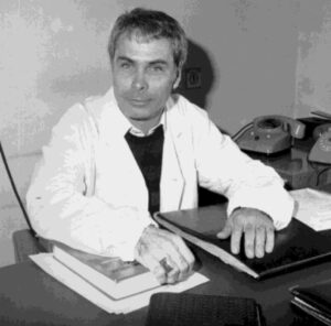 Man in white coat at a desk